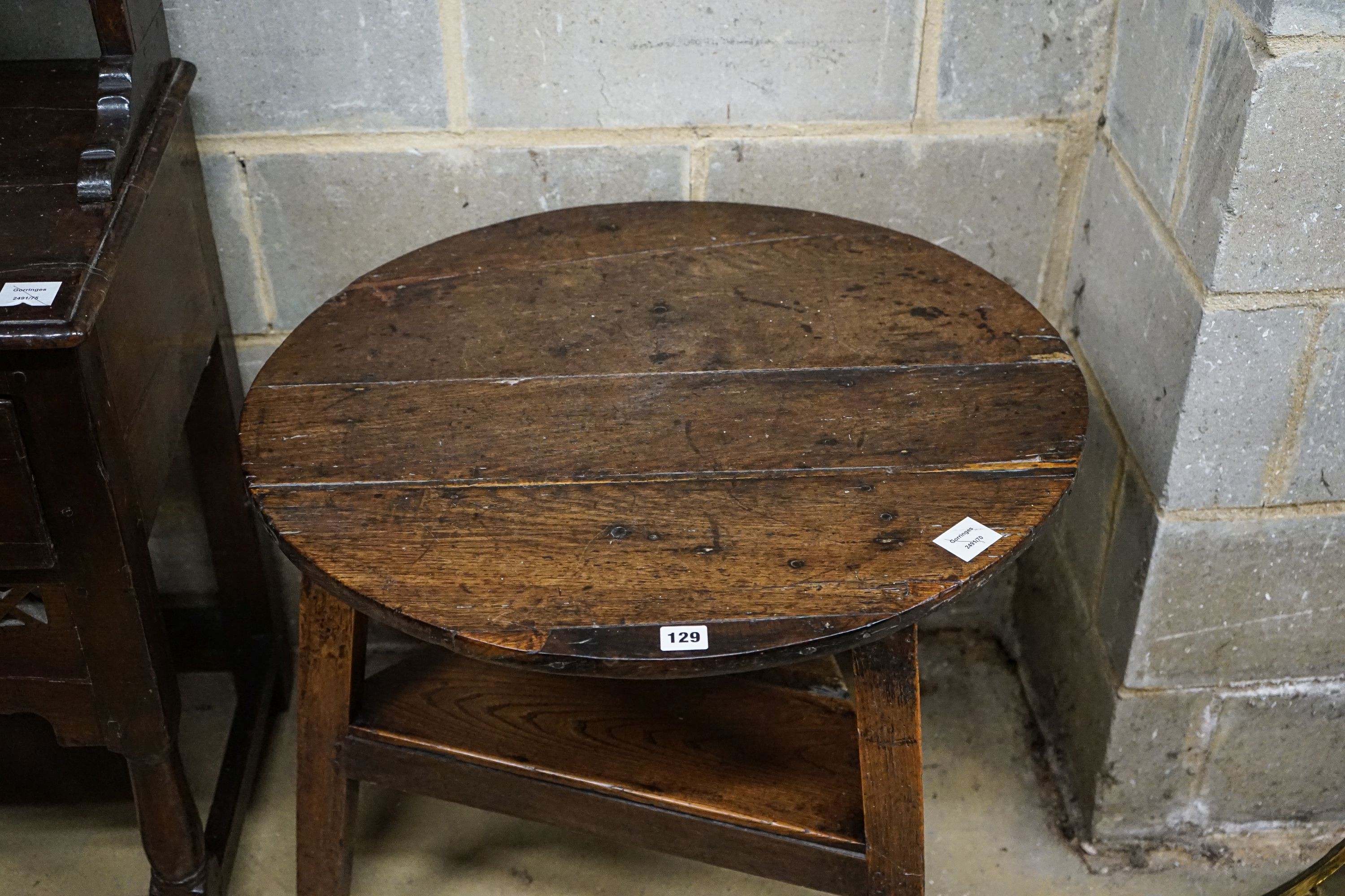 A George III oak cricket table, with circular top and triangular understage, diameter 67cm, height 65cm